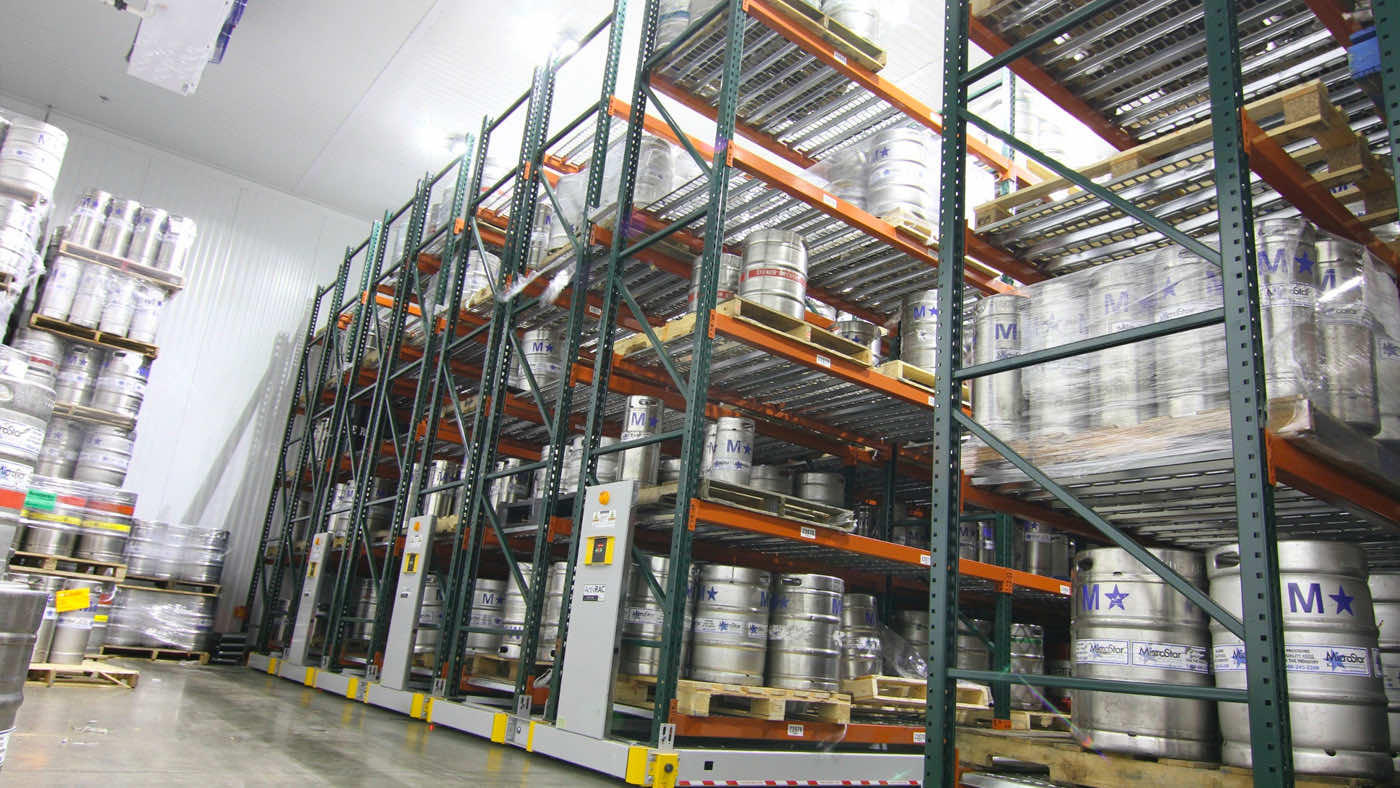 Beer kegs on powered mobile racking system in a refrigerated environment