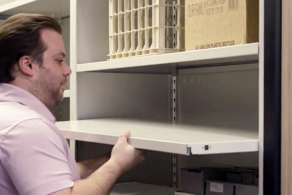 Benzie staff member adjusting the shelf of their Spacesaver 4-Post FreeSpan Shelving System