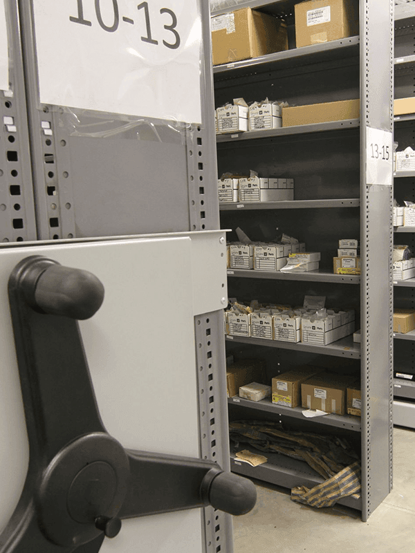 Close up view of the mechanical-assist wheel with auto parts on shelves