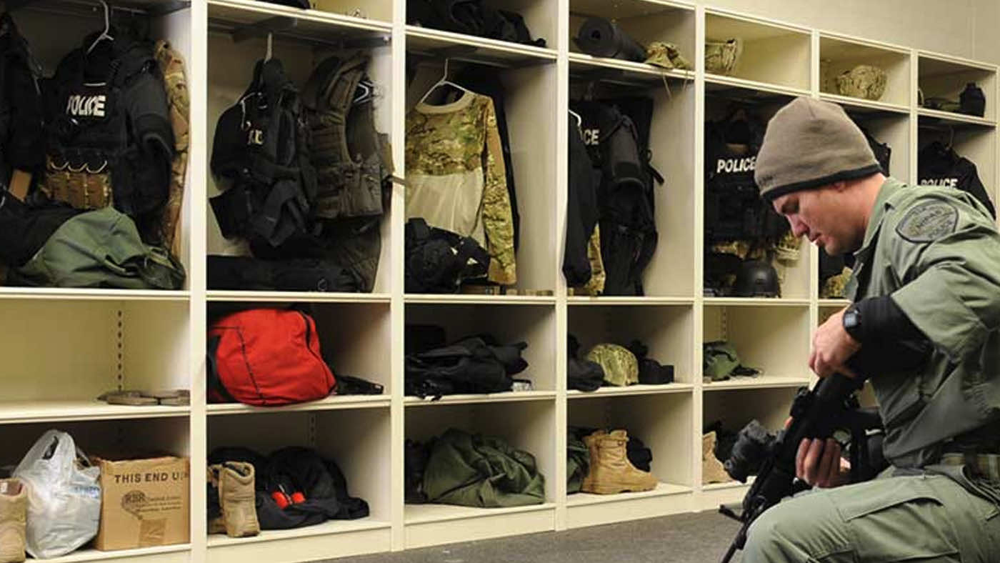 Officer checking rifle next to gear storage system