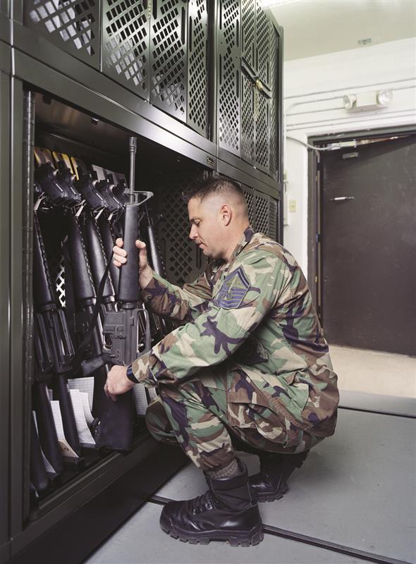 Soldier placing assault rifle into universal weapons rack