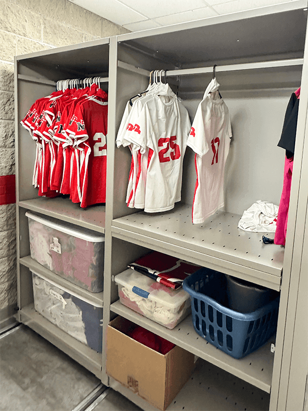 Spacesaver 4-Post FreeSpan Shelving mounted on a mechanical assist system holding totes and Northwestern jerseys