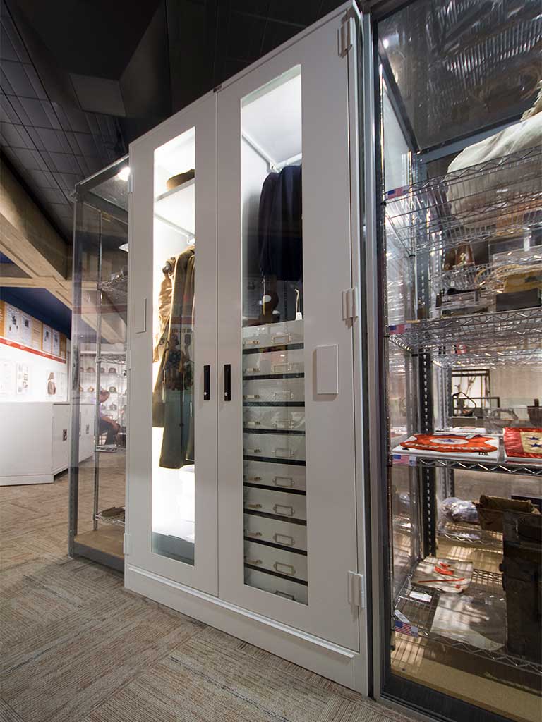 lighted museum cabinet with garment hanging and drawers