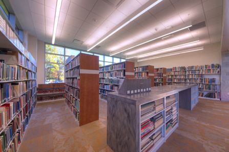 Library reading room with many bookshelves of different sizes full of books