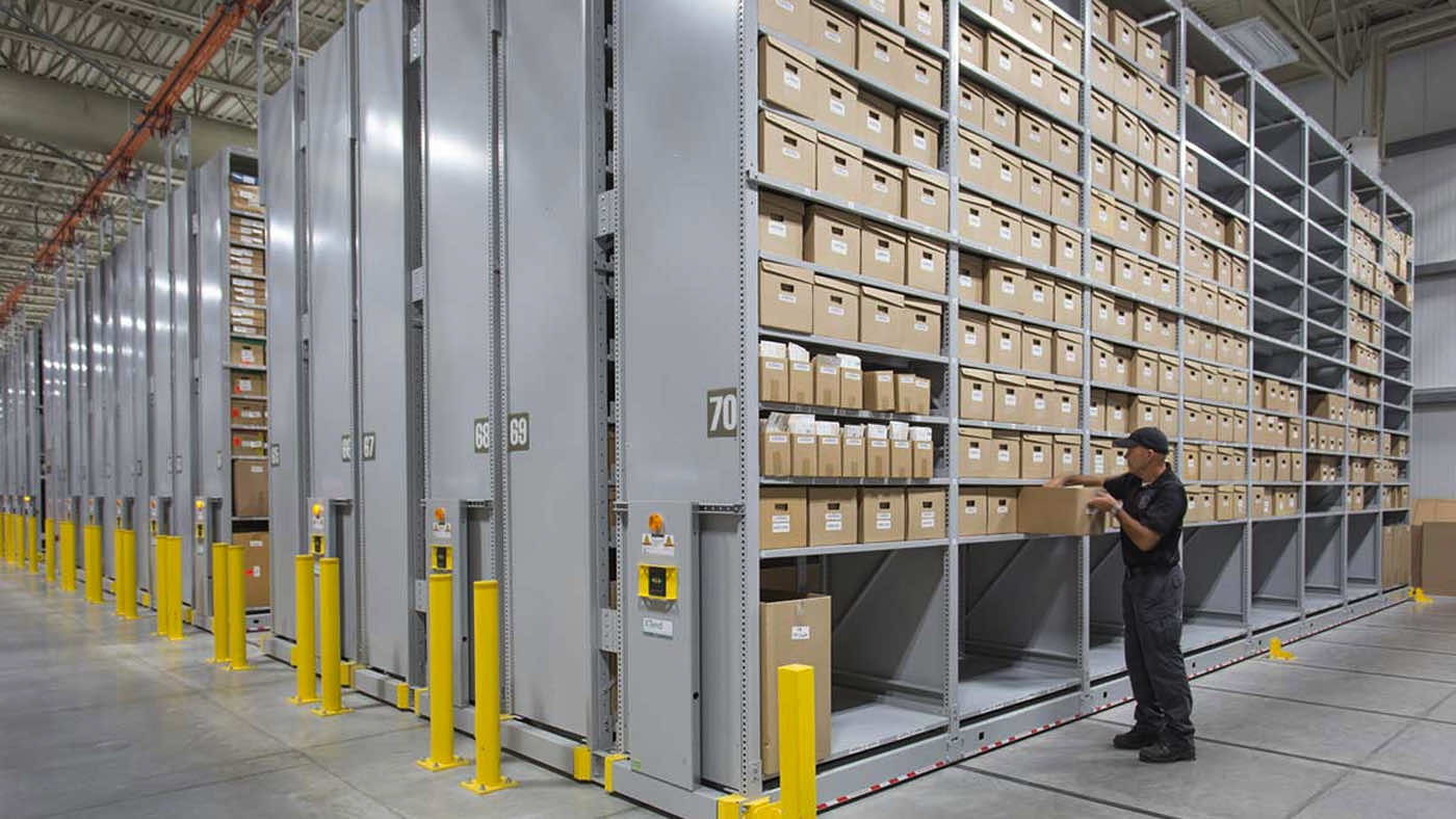 warehouse worker pulling a box of long-term evidence off of shelf on ActivRAC system