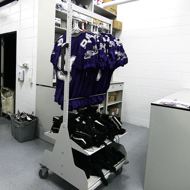 football jerseys, cleats, and shoulder pads on mobile cart