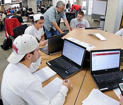 university library collabrative workspace with multiple students being assisted