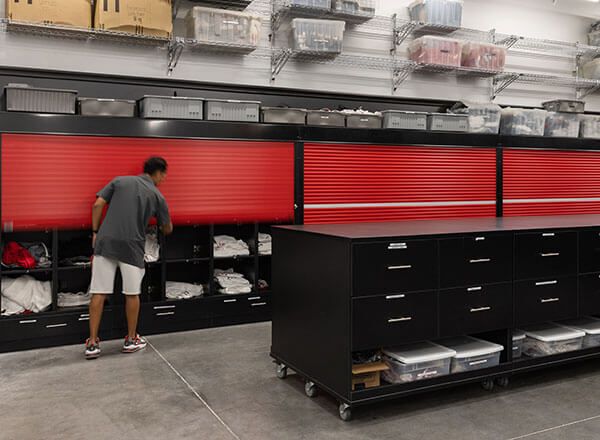 college athletic equipment room shelving with red tambour doors