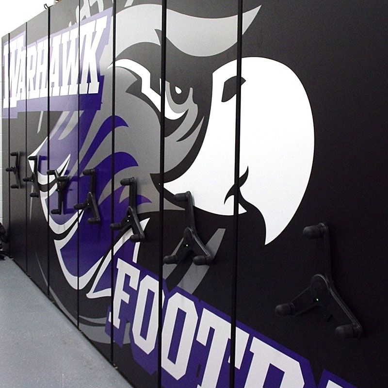 Mechanical assist mobile shelving system with Warhawks football logo on end panels