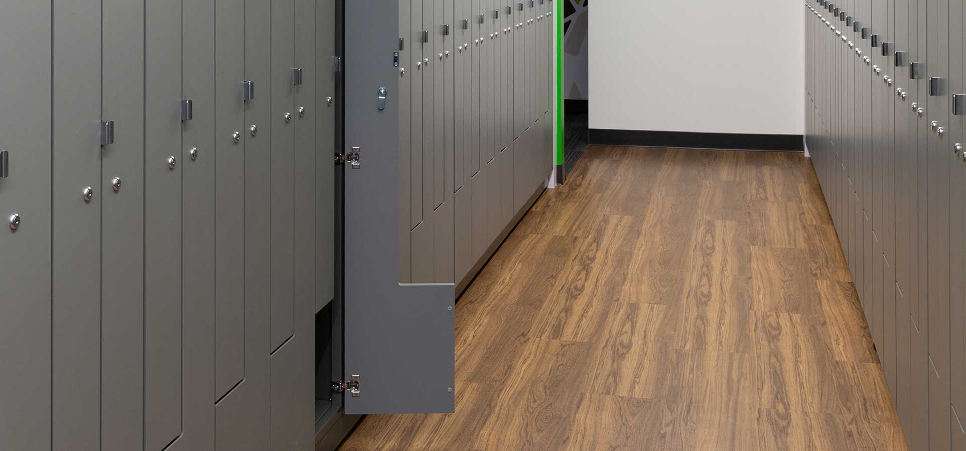 Two walls of employee storage lockers with one open on the left side