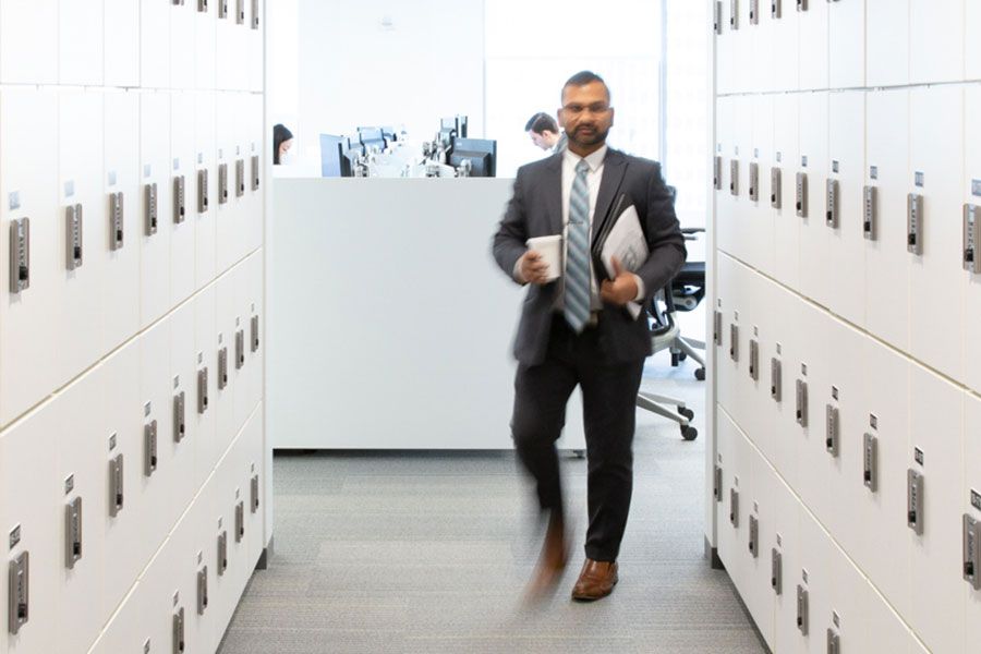 Office worker walking down the hall with day use lockers on both sides
