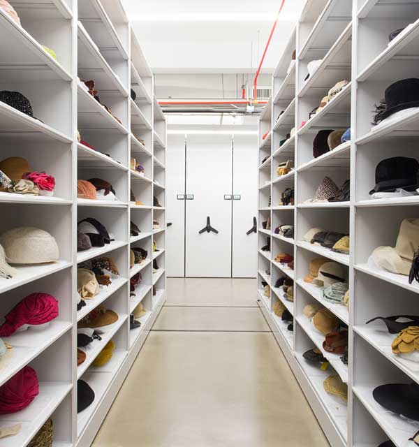 Hats stored on mechanical assist shelving system at fashion museum