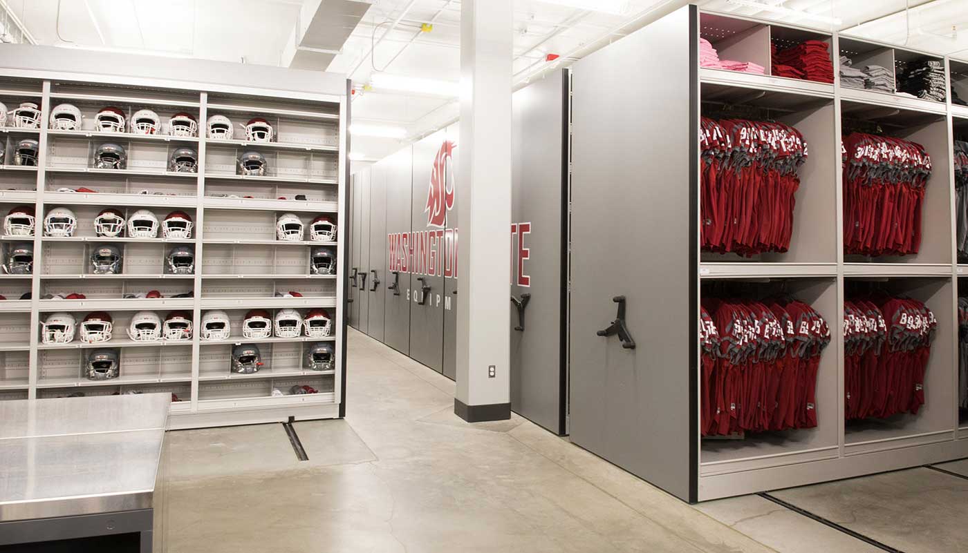 football helmets and jerseys being stored in two mechanical assist high-density mobile storage systems