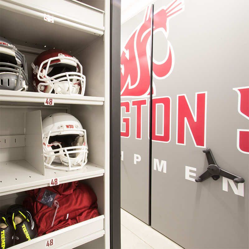 Helmets and other football equipment stored on two spacesaver mobile compact storage systems