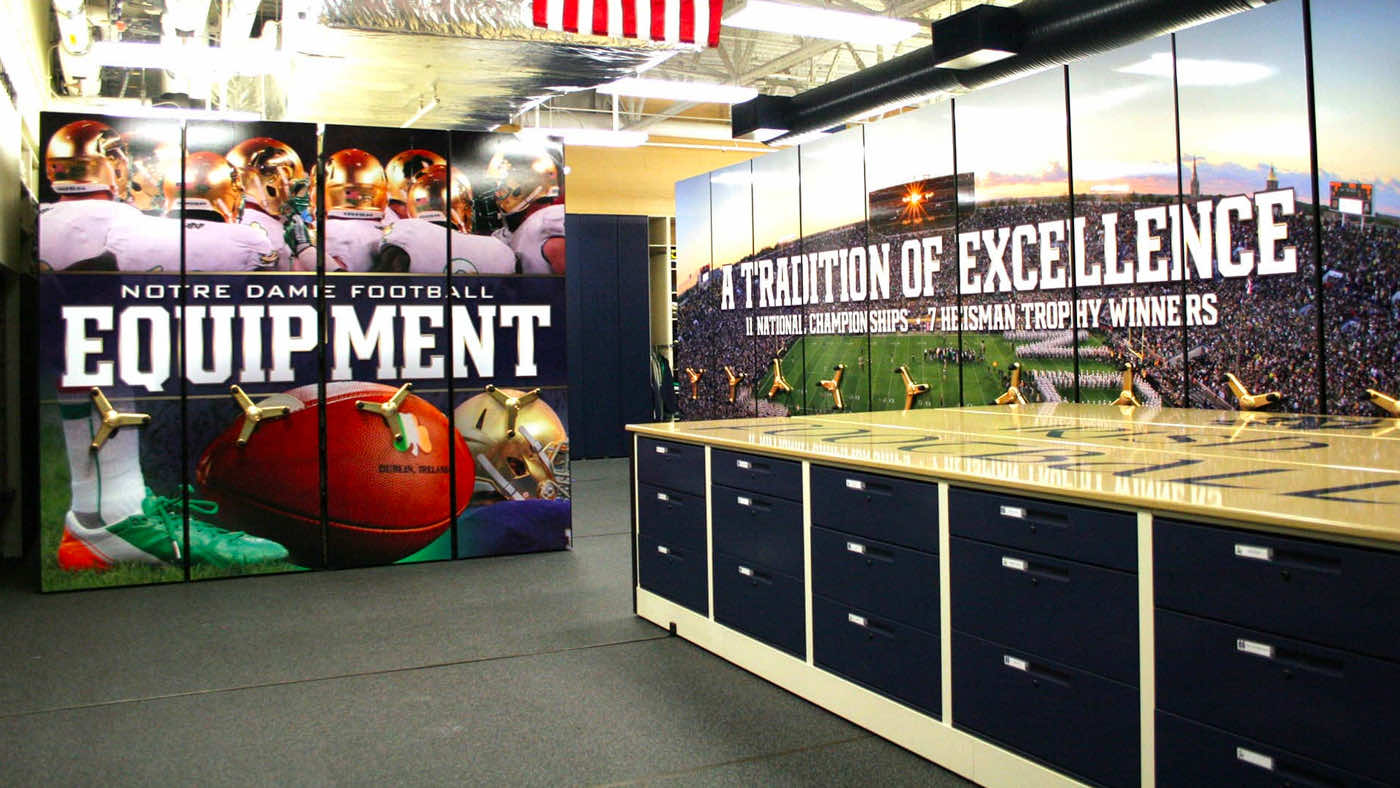 football equipment room with cabinet island and mobile shelving system for gear