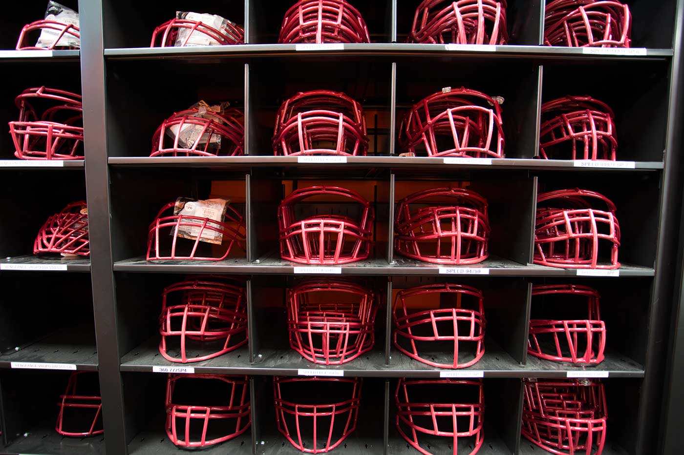 Red football helmets stored in cubbies on high-density mobile system