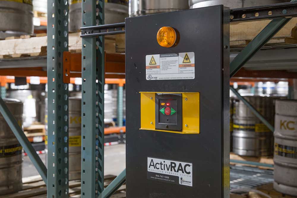 ActivRAC powered mobile racking system holding beer kegs and a forklift in the middle of the aisle