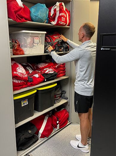 coach checking gear bags in Spacesaver athletic equipment cabinet