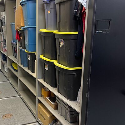 Stacks of totes containing athletic equipment on Spacesaver mechanical assist system