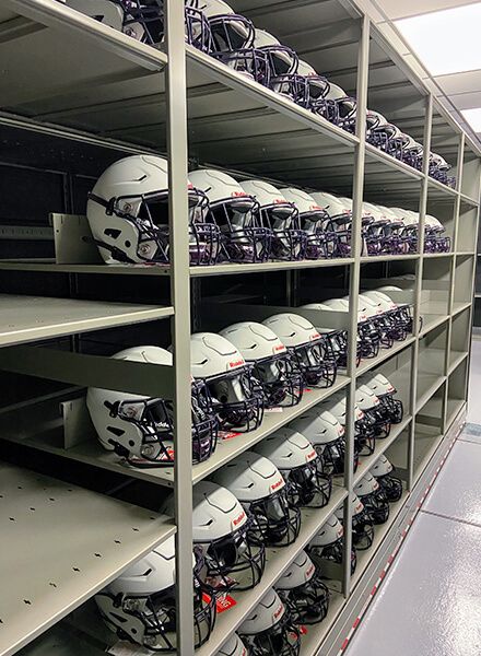 high school football helmets on spacesaver shelving 