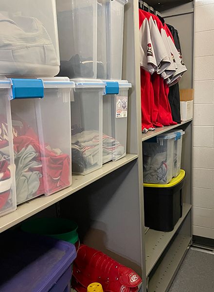 custom athletic equipment storage system holding jerseys and totes of gear