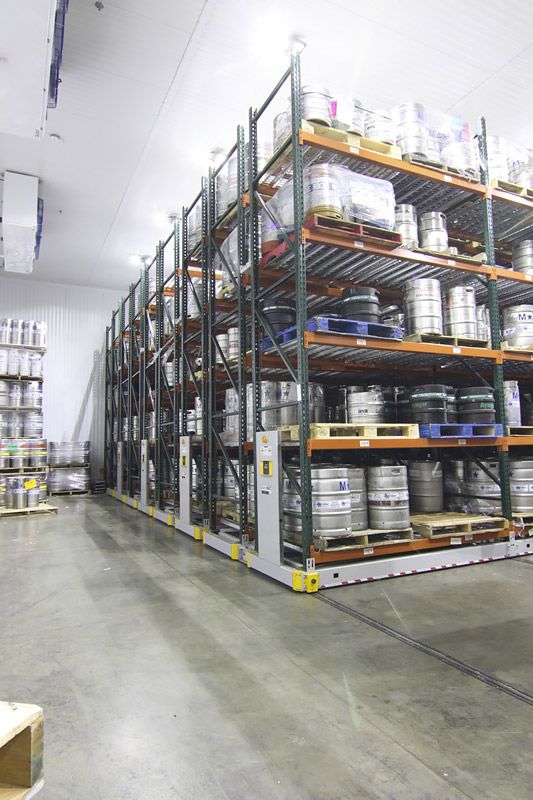 Beer kegs on powered mobile racking system in a warehouse