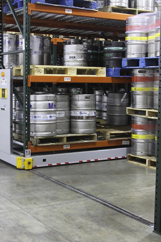 Beer kegs on a powered mobile pallet racking system in a warehouse