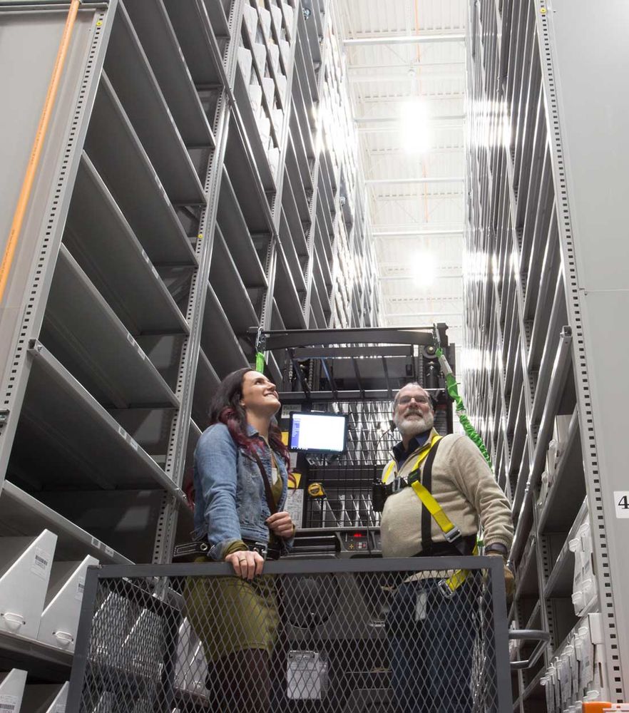 high-bay storage system with two people in a lift