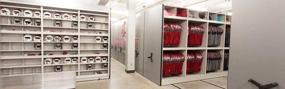 red and white football helmets and jerseys on mechanical assist storage system