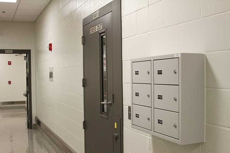 6 compartment wall-mounted gun locker mounted to concrete block wall