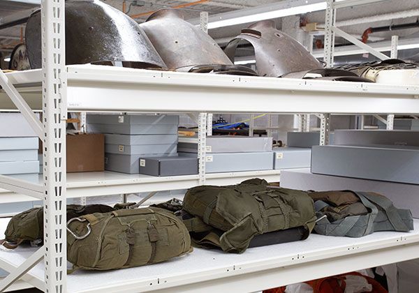 Museum military gear collection stored on Spacesaver shelving