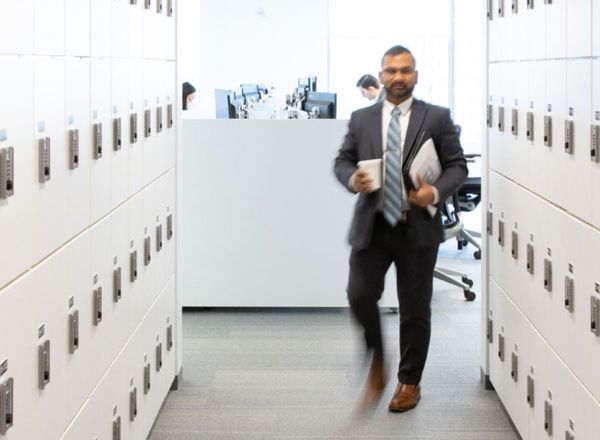 locker walls saving office space with worker in suit walking down the hall