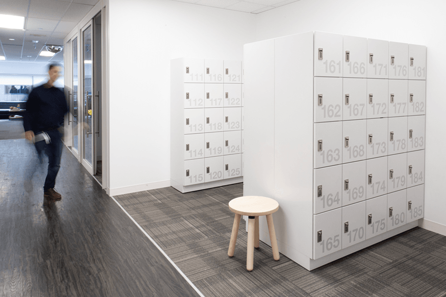 personal storage lockers in office with employee walking towards them