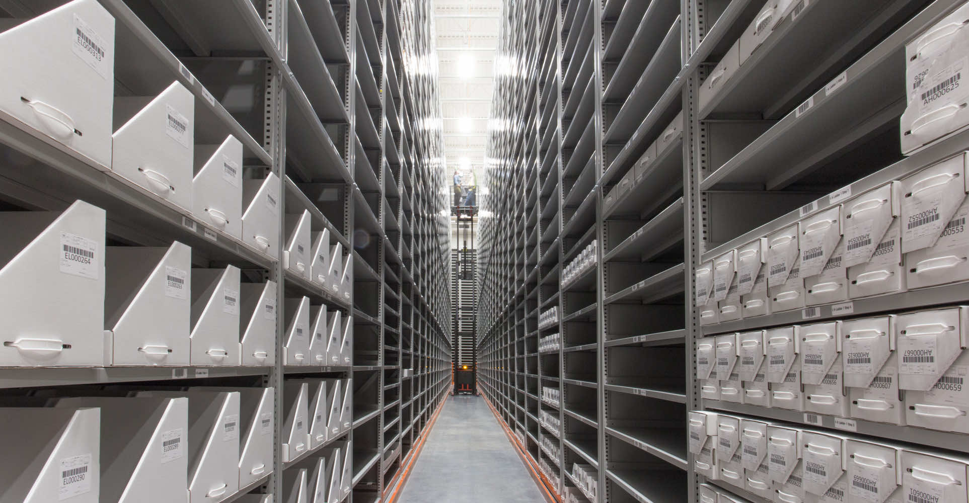 Aisle of high-bay installation holding boxes of books and files in an off-site facility