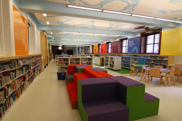 colorful grade school library with shelves of children's books around the walls