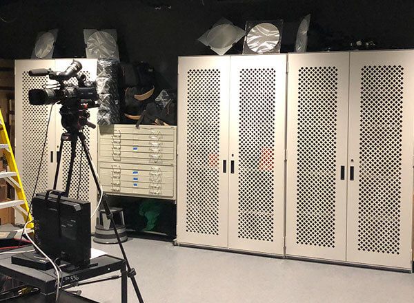 school videography room with camera on tripod and Spacesaver cabinets for video equipment storage