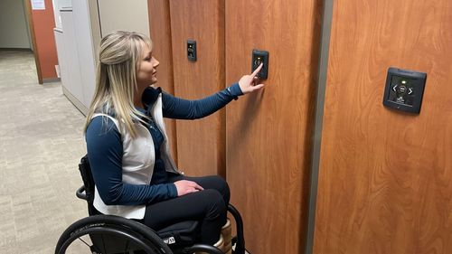 Woman in wheelchair operating Spacesaver powered mobile system