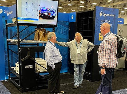 Spacesaver representative and show attendees talking by booth at IACP 2022