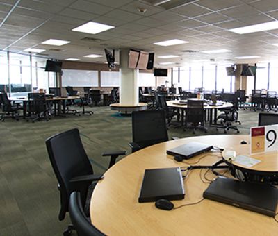student technology learning space with multiple tables covered in computers