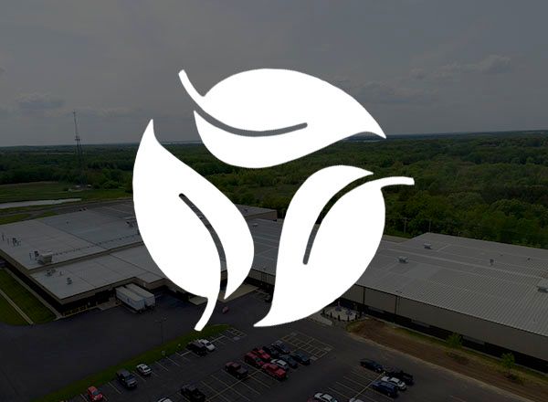 three leaves sustainability logo over image of Spacesaver manufacturing facility