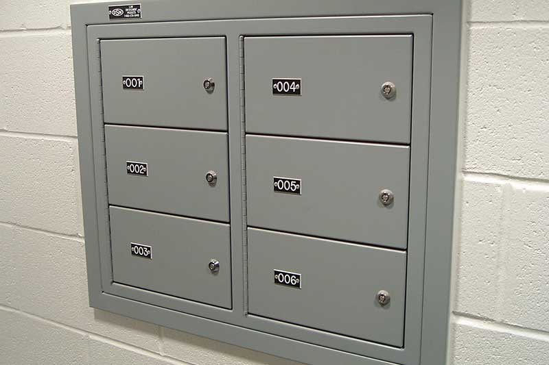 6 compartment wall-mounted gun locker mounted in concrete block wall