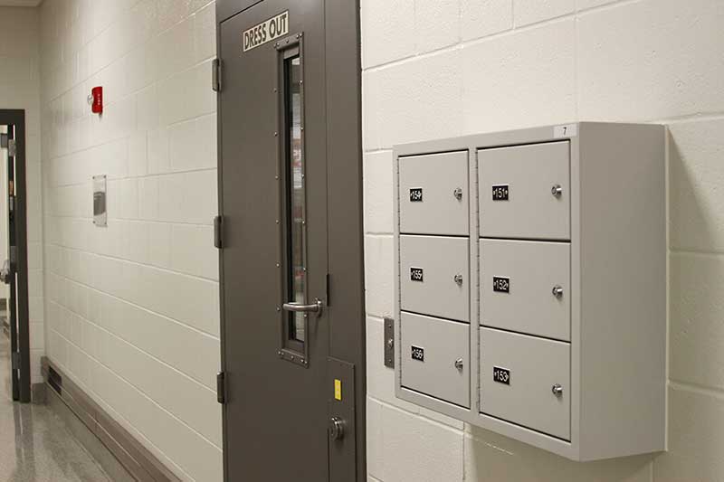 6 compartment wall-mounted gun locker mounted to concrete block wall