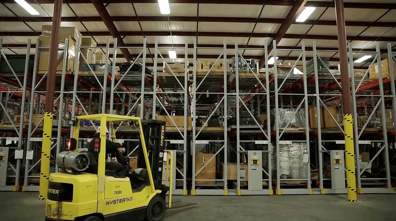 forklift and powered mobile shelving system in a warehouse