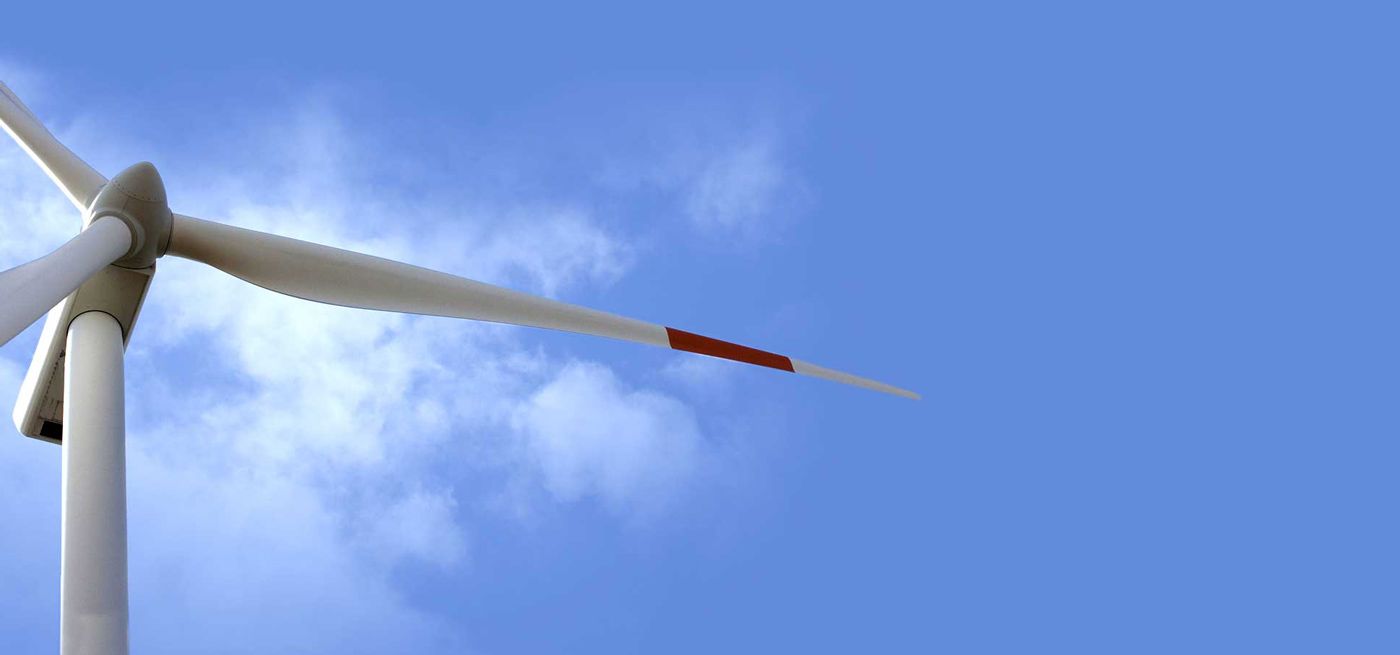 Wind turbine and a blue sky with a few clouds
