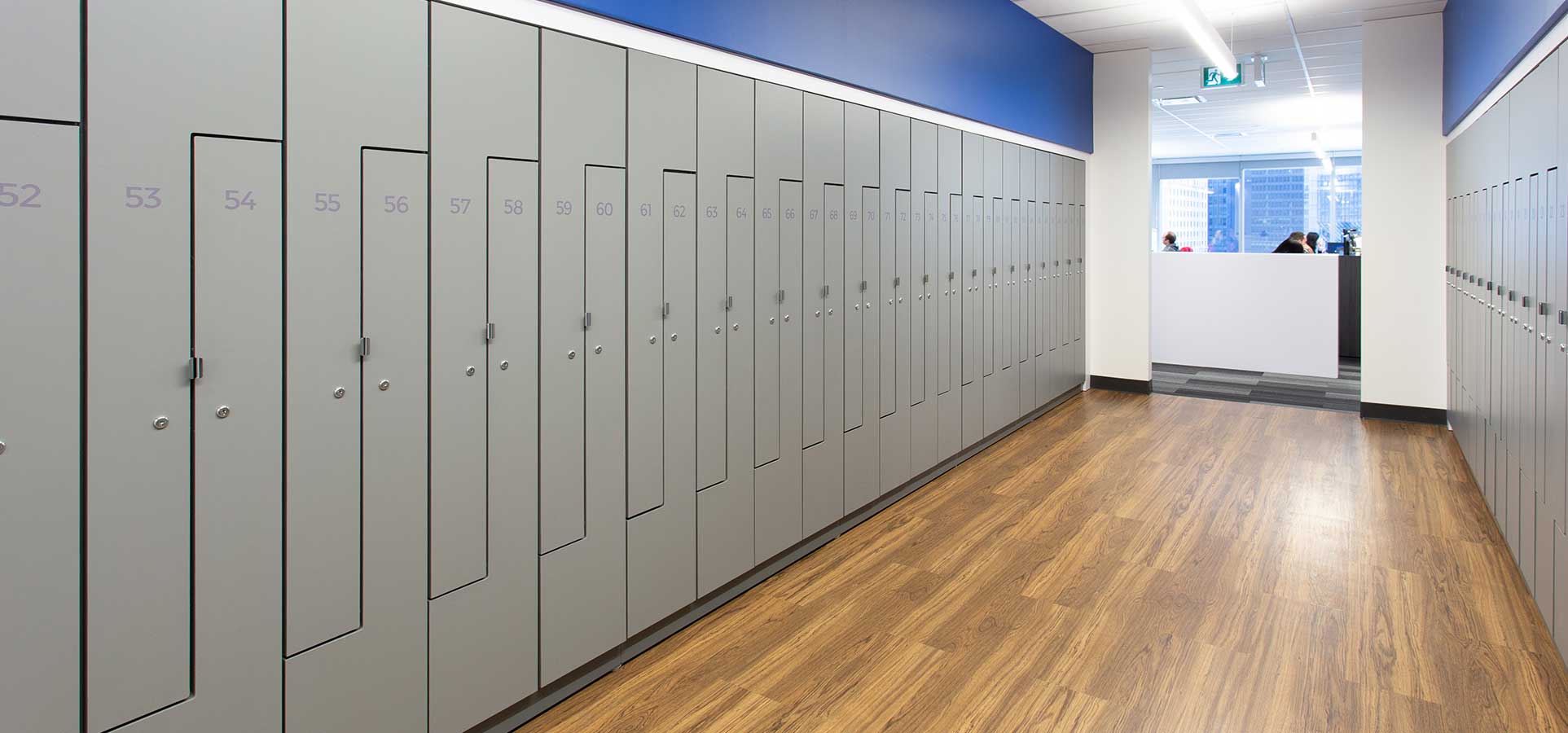 Wall of lockers in an office with wood floors