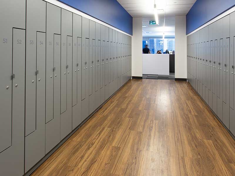 Locker walls on both sides of a hallway with a front desk through the far entry way